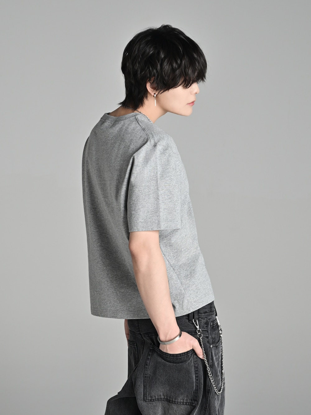 グレー系のTシャツ/カットソー、ブラック系のデニムパンツ、ブラウン系のブーツを着用したメンズの春コーディネートの3枚目の写真