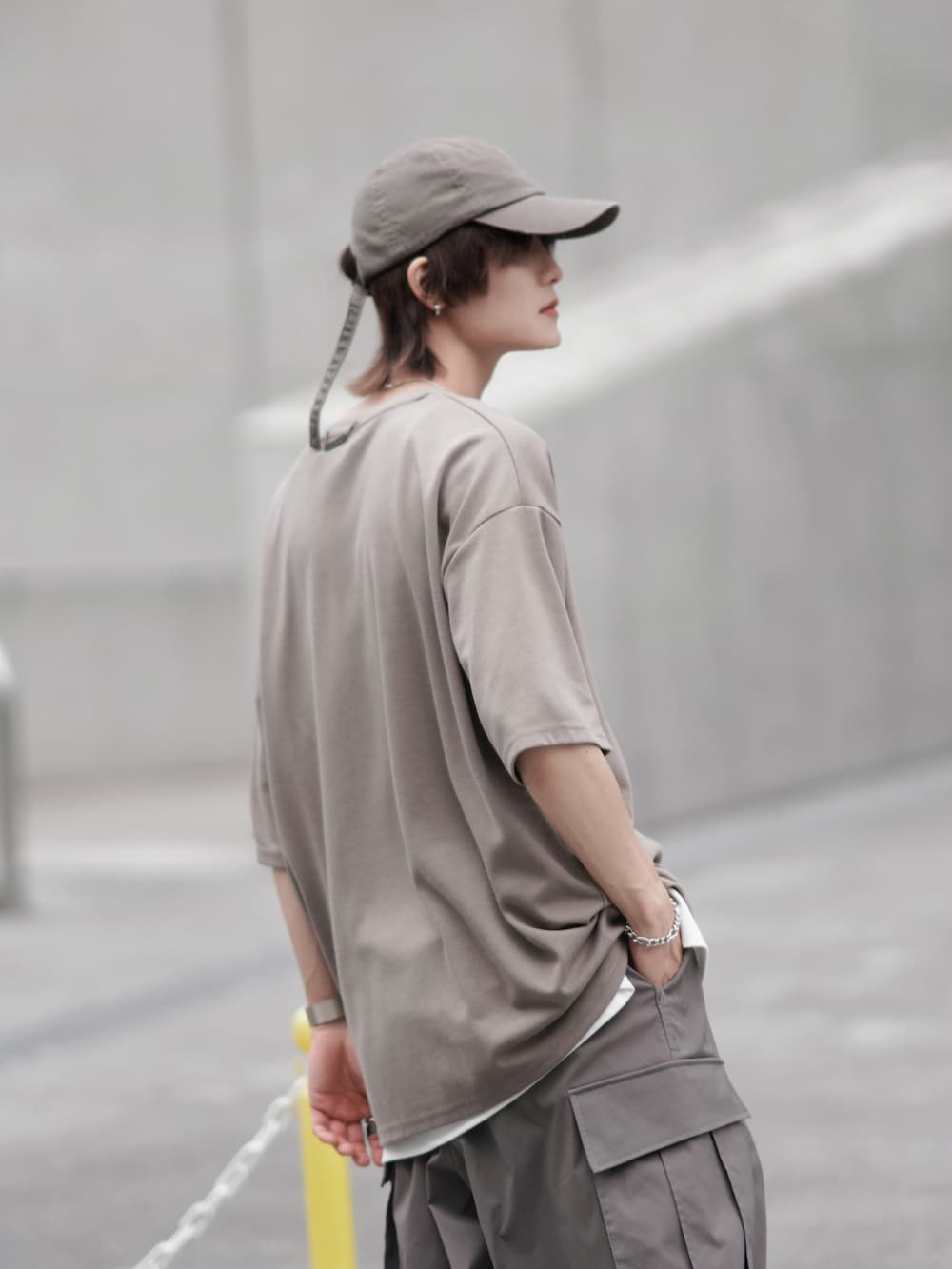 ベージュ系のTシャツ/カットソー、ホワイト系のタンクトップ、グレー系のカーゴパンツを着用したメンズの夏コーディネートの2枚目の写真