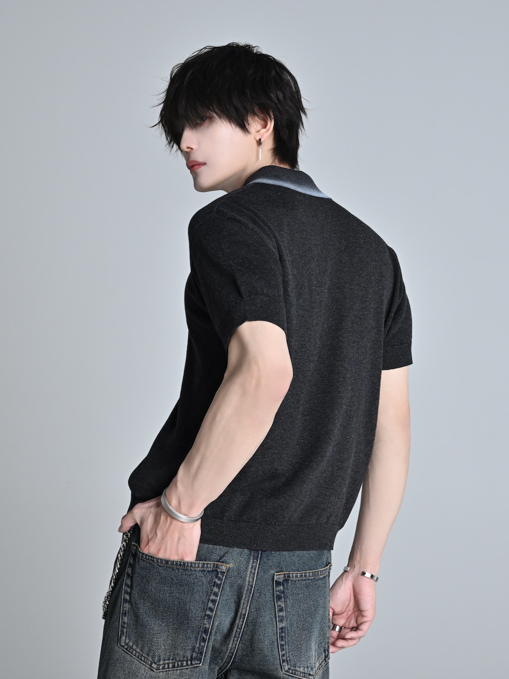 ブルー系のデニムパンツ、グレー系のポロシャツ、ブラック系のショルダーバッグを着用したメンズの春コーディネートの5枚目の写真