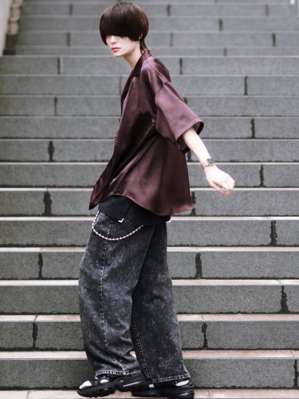 ブラック系のスニーカー、ブラック系のタンクトップ、ブラック系のデニムパンツを着用したメンズの春コーディネートの2枚目の写真