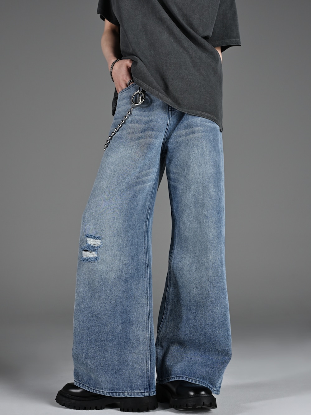 グレー系のTシャツ/カットソー、ブルー系のデニムパンツ、ブラック系のブーツを着用したメンズの夏コーディネートの2枚目の写真