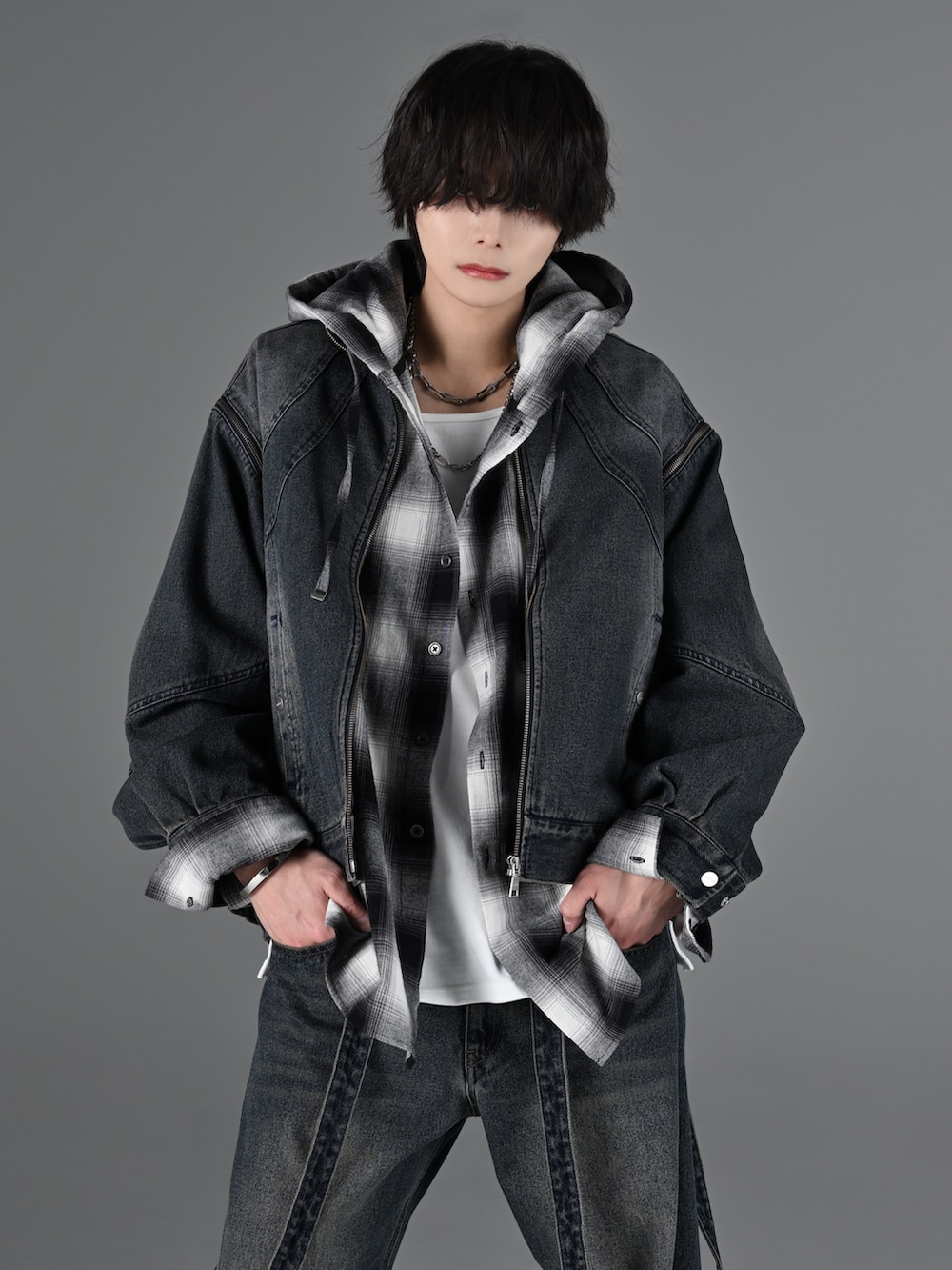 ブルー系のデニムパンツ、ホワイト系のスニーカー、グレー系のタンクトップを着用したメンズの冬コーディネートの2枚目の写真