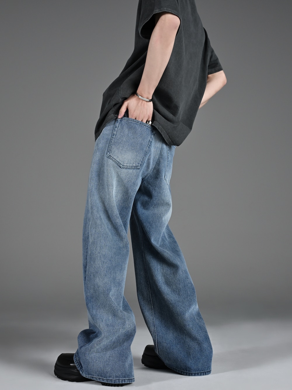 ブラック系のブーツ、グレー系のTシャツ/カットソー、ブルー系のデニムパンツを着用したメンズの春コーディネートの5枚目の写真