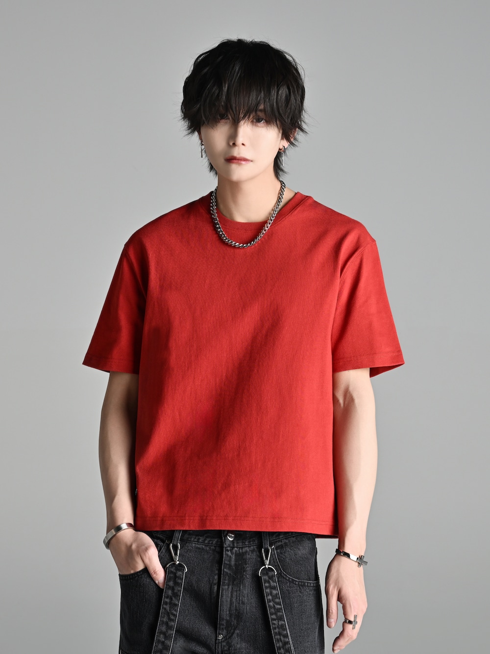 ブラック系のデニムパンツ、レッド系のTシャツ/カットソー、ブラック系のブーツを着用したメンズの春コーディネートの2枚目の写真