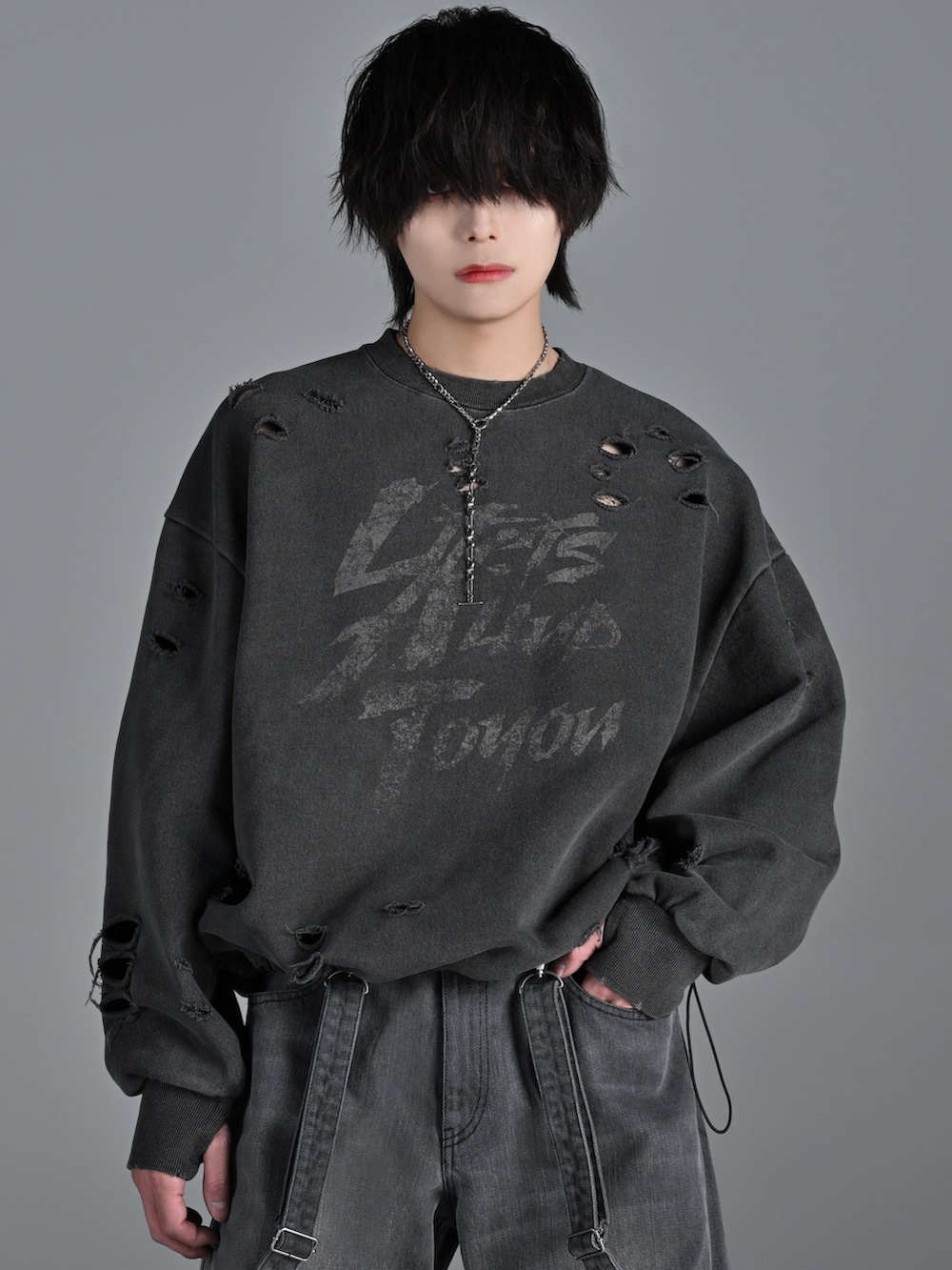 グレー系のスウェット、グレー系のデニムパンツ、シルバー系のネックレスを着用したメンズの冬コーディネートの2枚目の写真