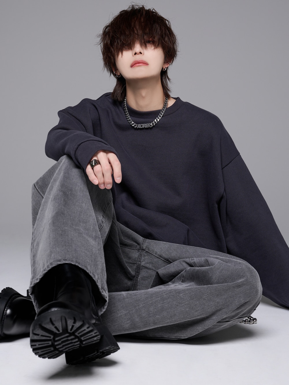 グレー系のデニムパンツ、グレー系のスウェット、ブラック系のブーツを着用したメンズの冬コーディネートの2枚目の写真