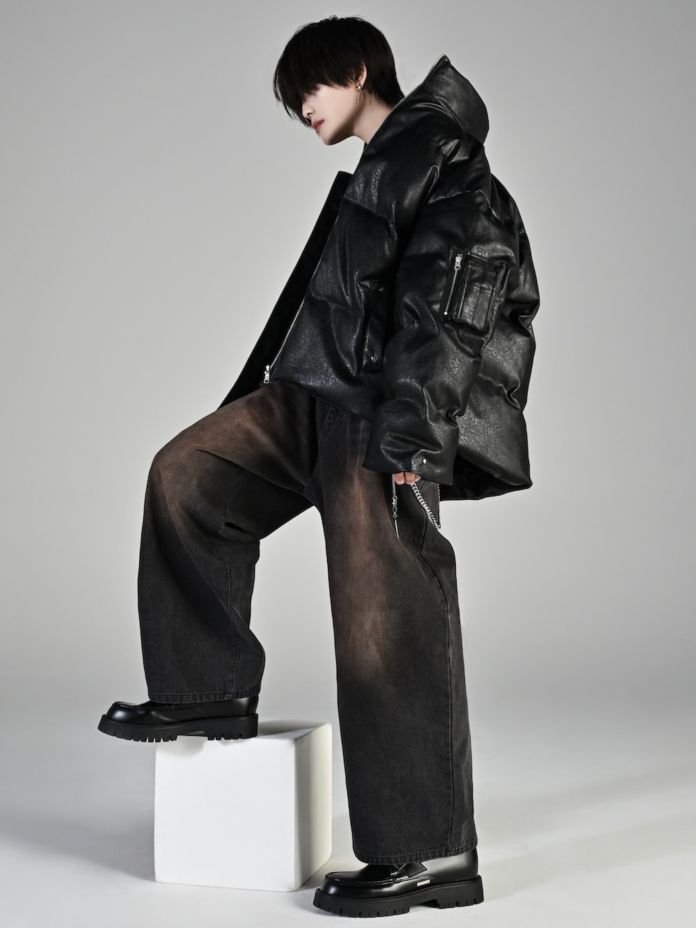 ブラック系のローファー、ブラック系のダウンジャケット/コート、ブラック系のデニムパンツを着用したメンズの秋コーディネートの2枚目の写真