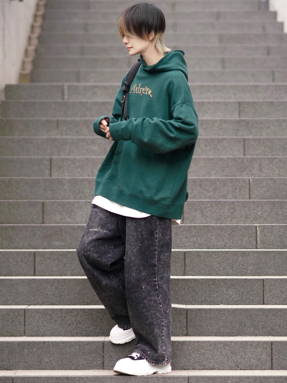 ホワイト系のTシャツ/カットソー、ブラック系のデニムパンツ、ブラック系のスニーカーを着用したメンズの冬コーディネートの2枚目の写真