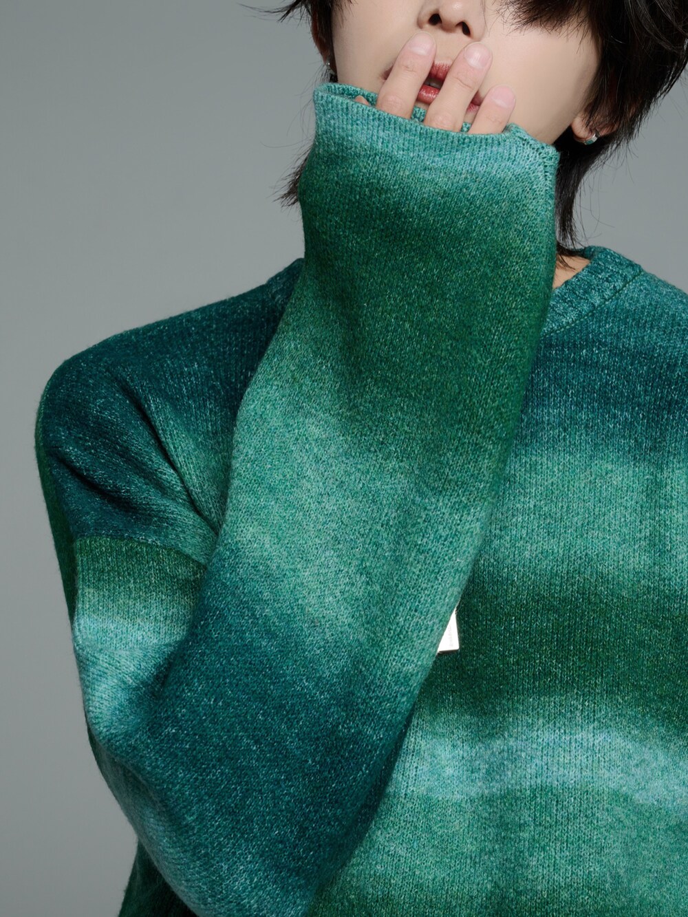 ブラック系のデニムパンツ、ブラック系のブーツ、グリーン系のニット/セーターを着用したメンズの秋コーディネートの4枚目の写真