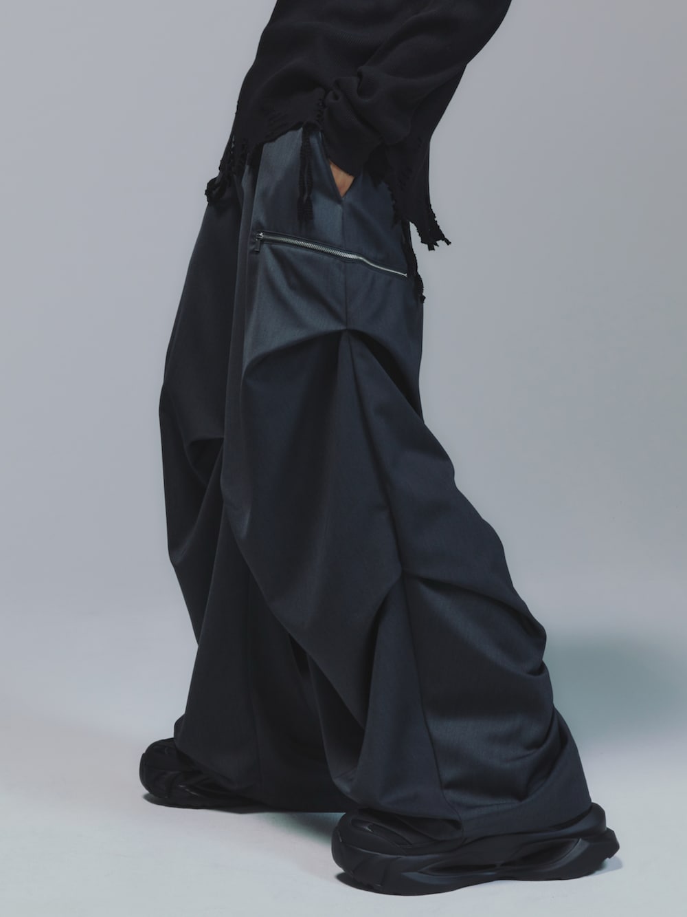 ブラック系のパーカー、レッド系のタンクトップ、ブラック系のスラックスを着用したメンズの秋コーディネートの3枚目の写真