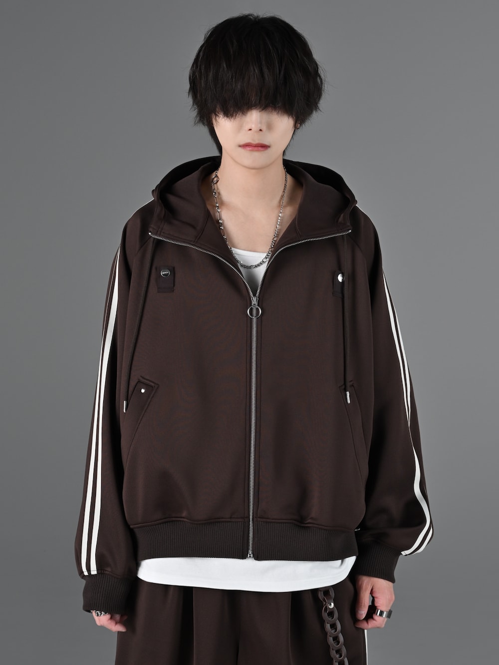 ホワイト系のスニーカー、グレー系のタンクトップ、ブラウン系のブルゾンを着用したメンズの冬コーディネートの4枚目の写真