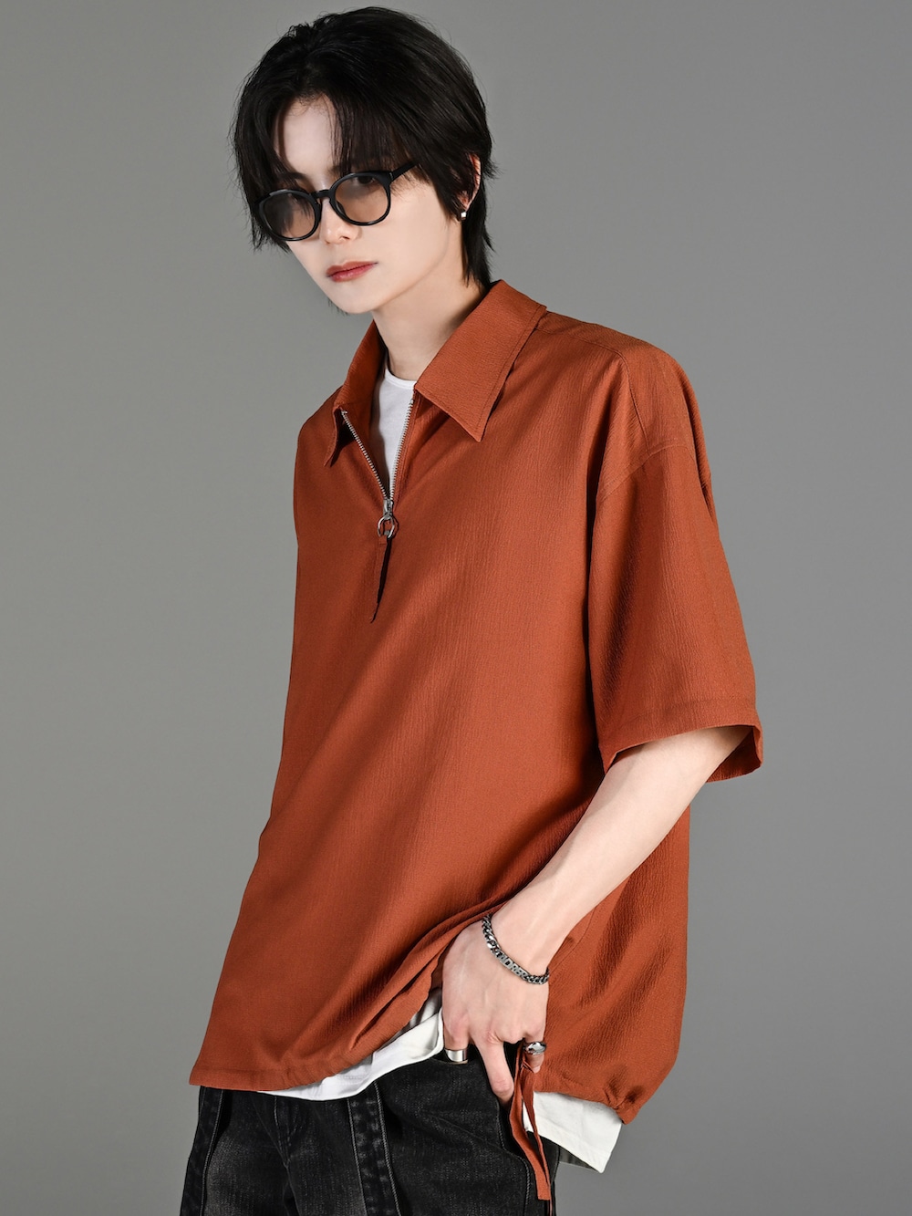 グレー系のタンクトップ、ブラック系のデニムパンツ、ホワイト系のスニーカーを着用したメンズの春コーディネートの3枚目の写真