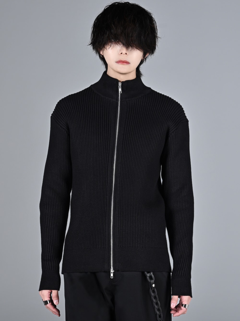 ブラック系のスラックス、ブラック系のブーツ、ブラック系のニット/セーターを着用したメンズの冬コーディネートの3枚目の写真