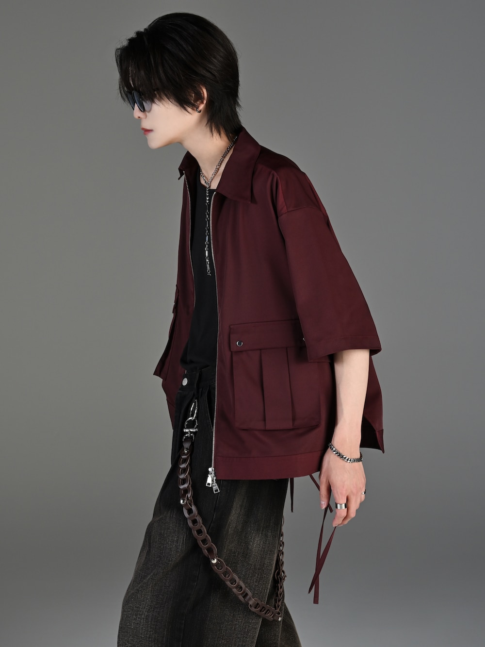 ブラック系のデニムパンツ、ブラック系のブーツ、レッド系のタンクトップを着用したメンズの春コーディネートの3枚目の写真