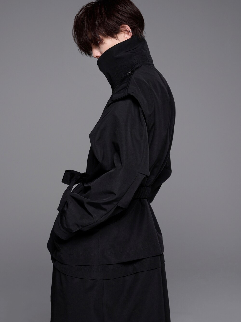 ブラック系のニット/セーター、ブラック系のトレンチコート、ブラック系のリングを着用したメンズの冬コーディネートの3枚目の写真