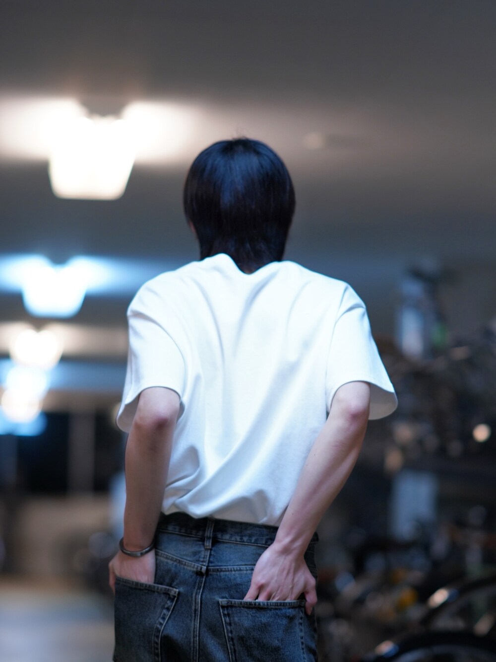 ブラック系のスニーカー、ブルー系のデニムパンツ、ホワイト系のTシャツ/カットソーを着用したメンズの春コーディネートの3枚目の写真