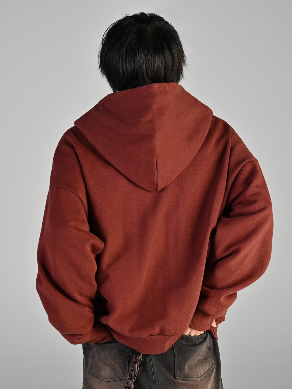 ホワイト系のスニーカー、ブラウン系のパーカー、ブラック系のデニムパンツを着用したメンズの秋コーディネートの3枚目の写真