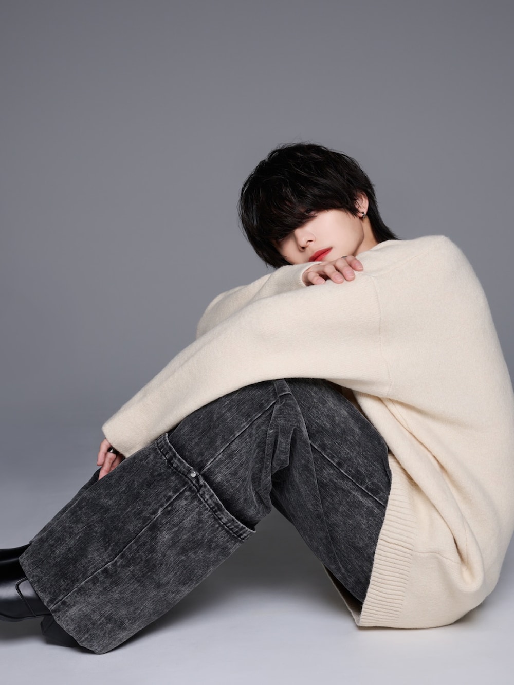 ブラック系のデニムパンツ、ブラック系のブーツ、ホワイト系のニット/セーターを着用したメンズの秋コーディネートの5枚目の写真