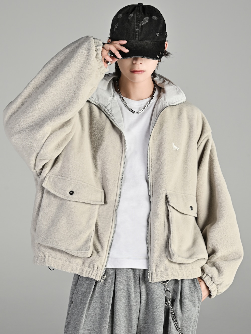 ベージュ系のブーツ、ホワイト系のブルゾン、グレー系のスウェットパンツを着用したメンズの秋コーディネートの2枚目の写真