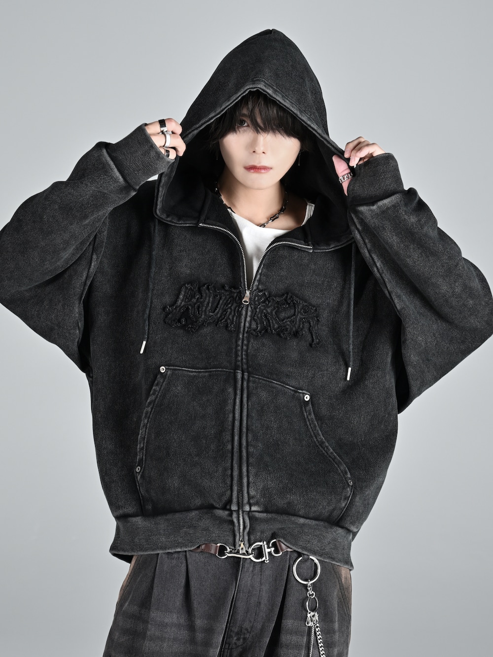 レッド系のタンクトップ、グレー系のパーカー、ブルー系のデニムパンツを着用したメンズの秋コーディネートの3枚目の写真