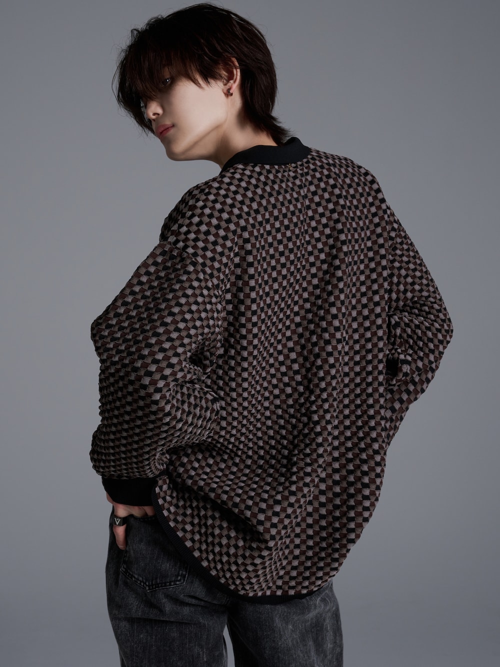 ブラック系のデニムパンツ、ブラウン系のポロシャツ、ブラック系のブーツを着用したメンズの冬コーディネートの5枚目の写真