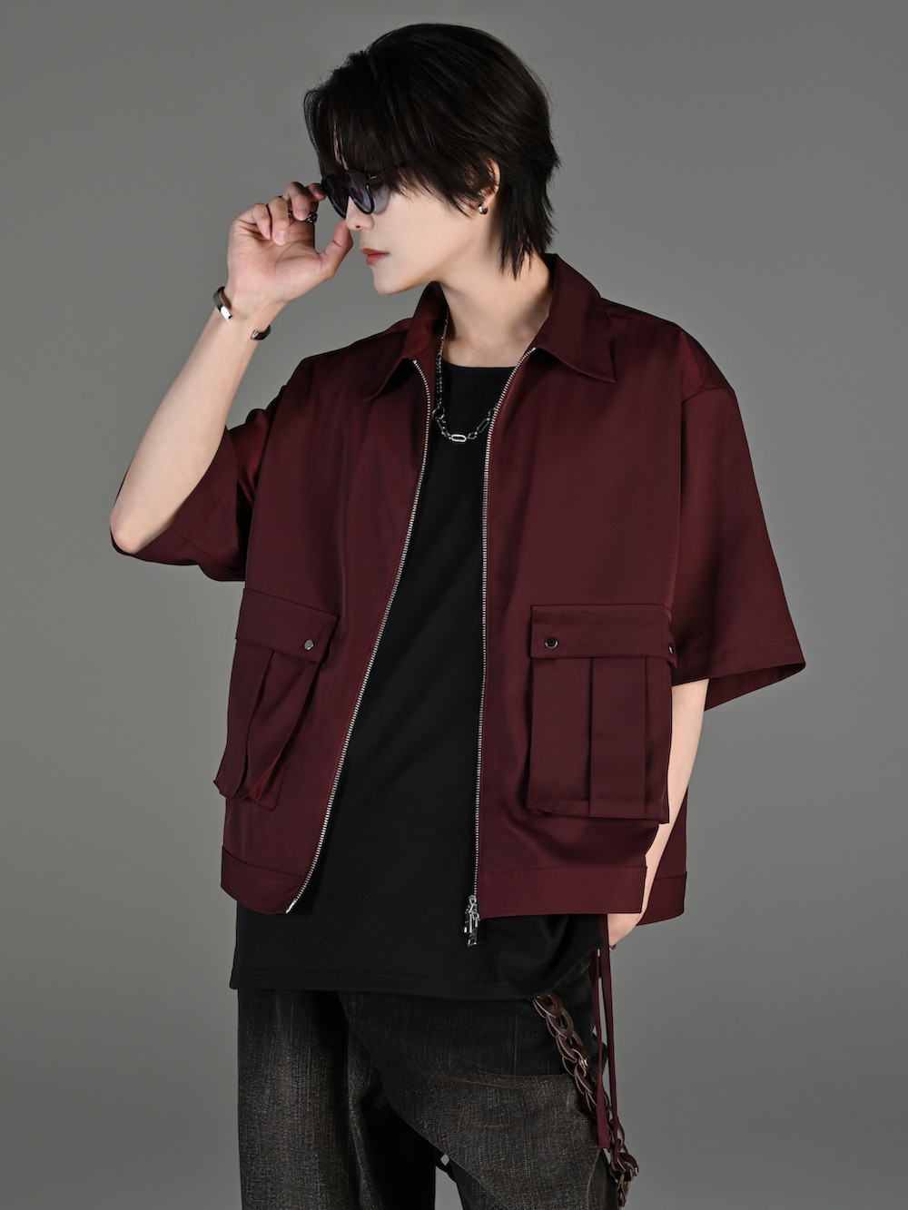 ブラック系のデニムパンツ、ブラック系のブーツ、レッド系のタンクトップを着用したメンズの春コーディネートの2枚目の写真