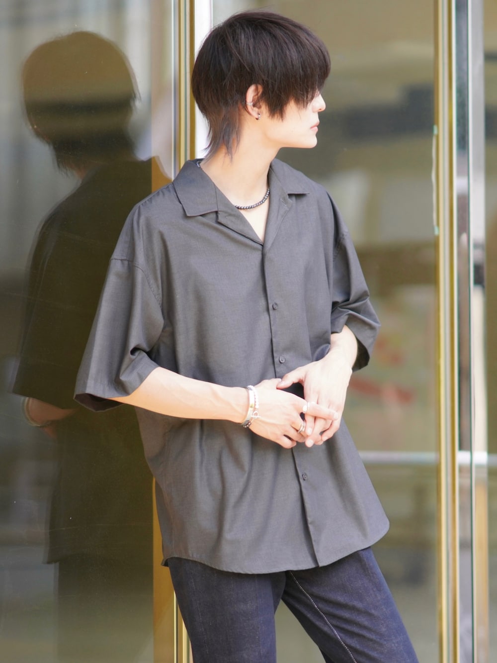 グレー系のシャツ/ブラウス、ホワイト系のタンクトップ、ブルー系のデニムパンツを着用したメンズの夏コーディネートの3枚目の写真