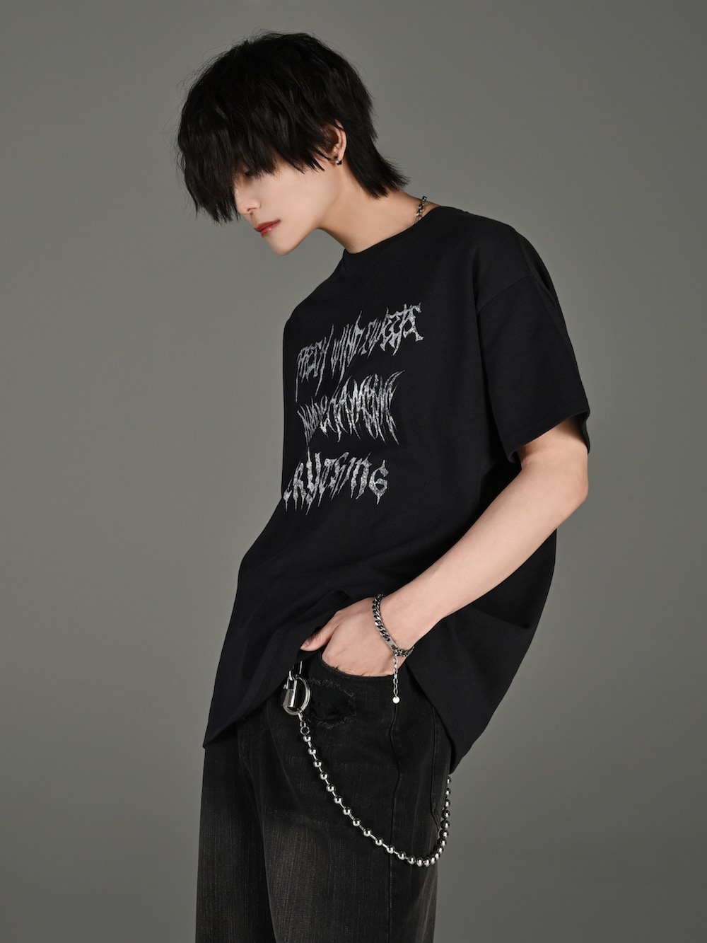 ブラック系のデニムパンツ、ブラック系のブーツ、ブラック系のショルダーバッグを着用したメンズの春コーディネートの3枚目の写真