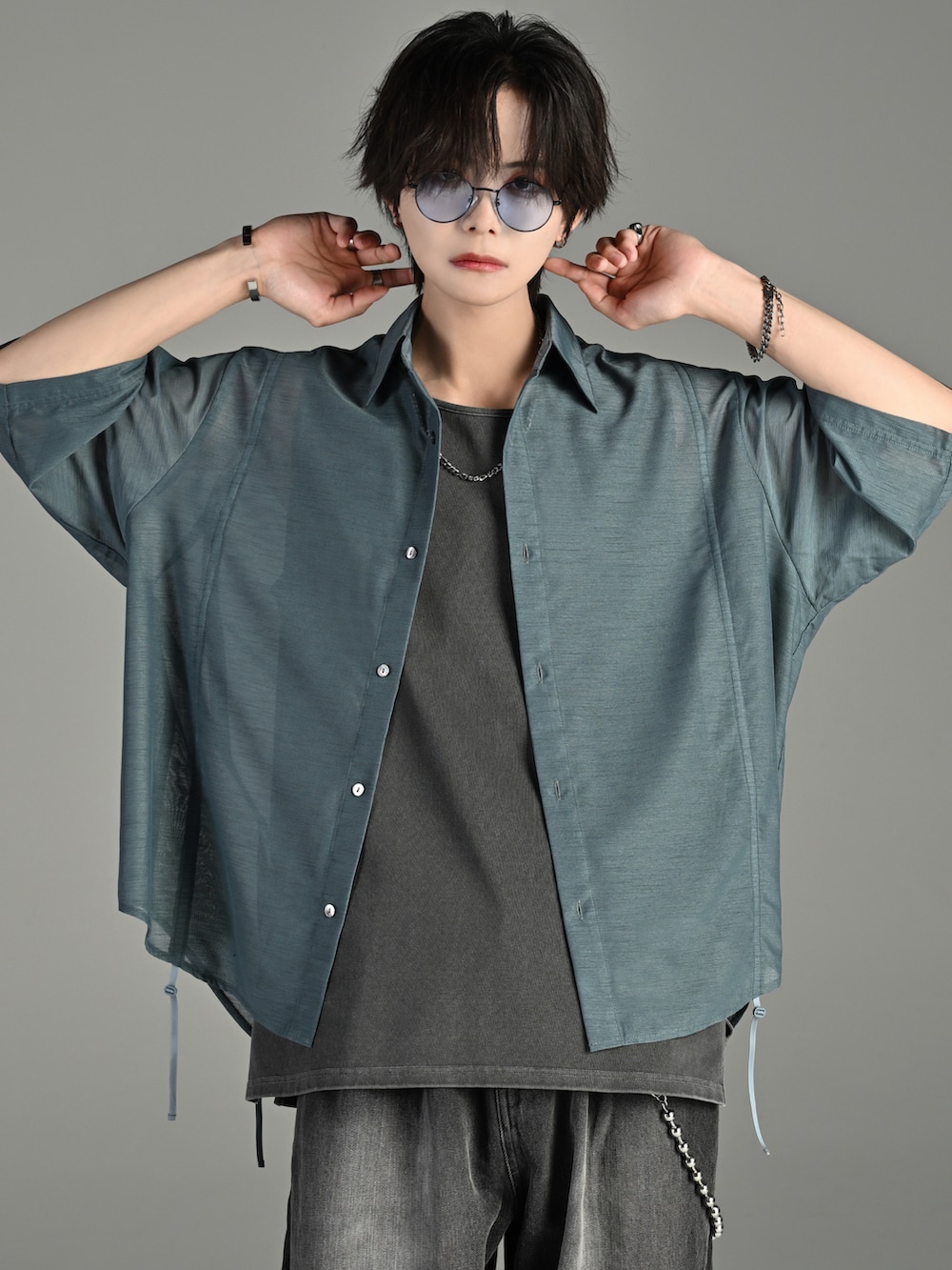 ブラック系のデニムパンツ、ブラック系のブーツ、ブラック系のショルダーバッグを着用したメンズの夏コーディネートの2枚目の写真