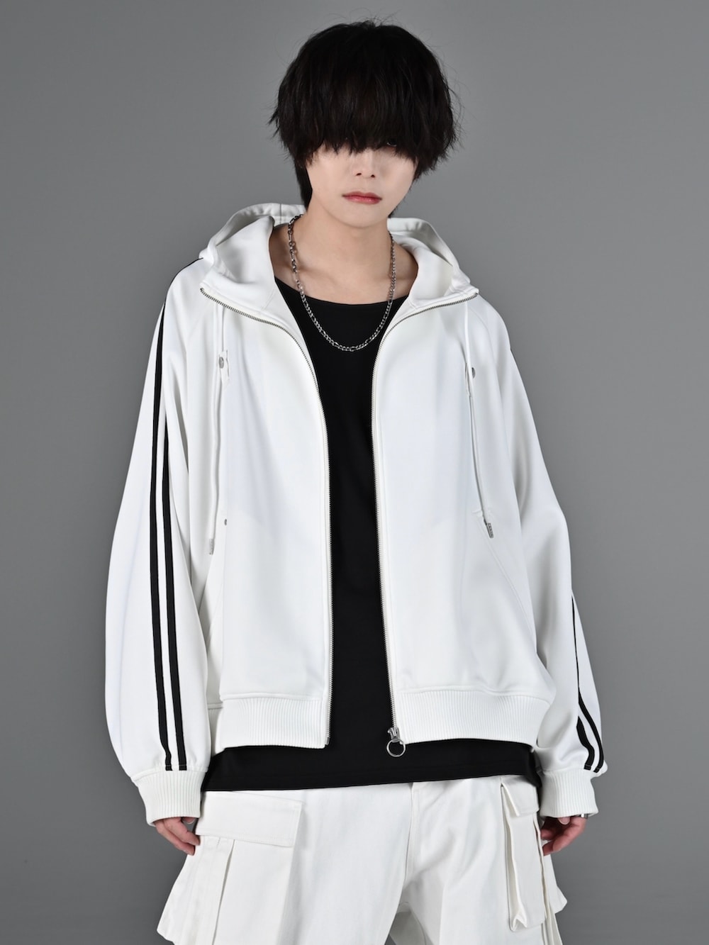 レッド系のタンクトップ、ホワイト系のスニーカー、ホワイト系のブルゾンを着用したメンズの冬コーディネートの3枚目の写真