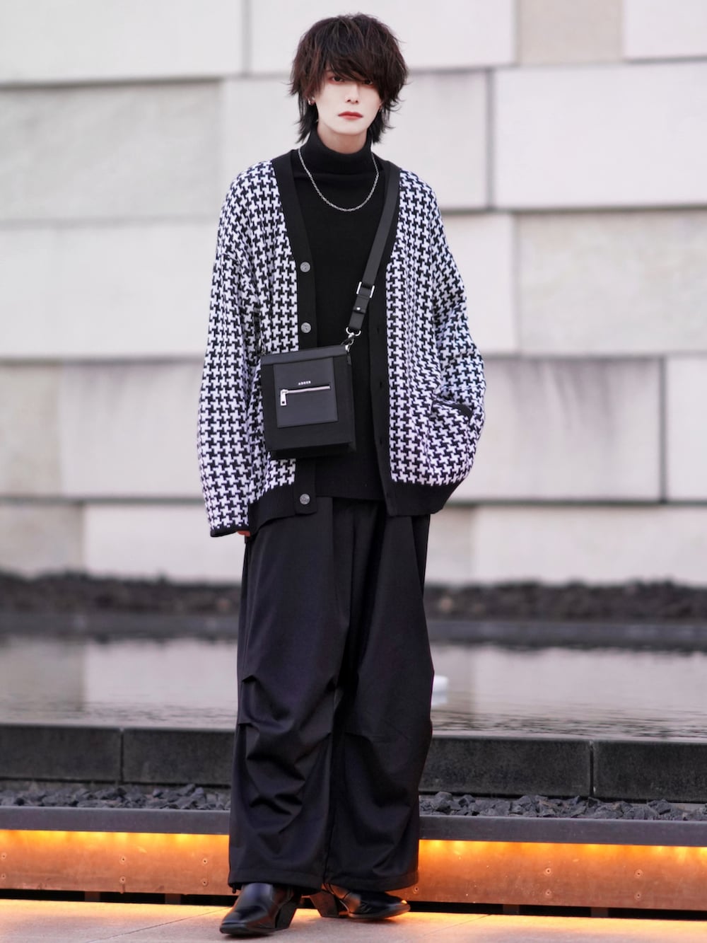 ブラック系のニット/セーター、ブラック系のブーツ、ブラック系のカーゴパンツを着用したメンズの冬コーディネートの3枚目の写真