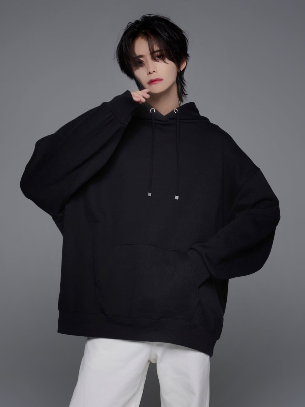 ブラック系のスニーカー、ブラック系のパーカー、ホワイト系のデニムパンツを着用したメンズの夏コーディネートの2枚目の写真