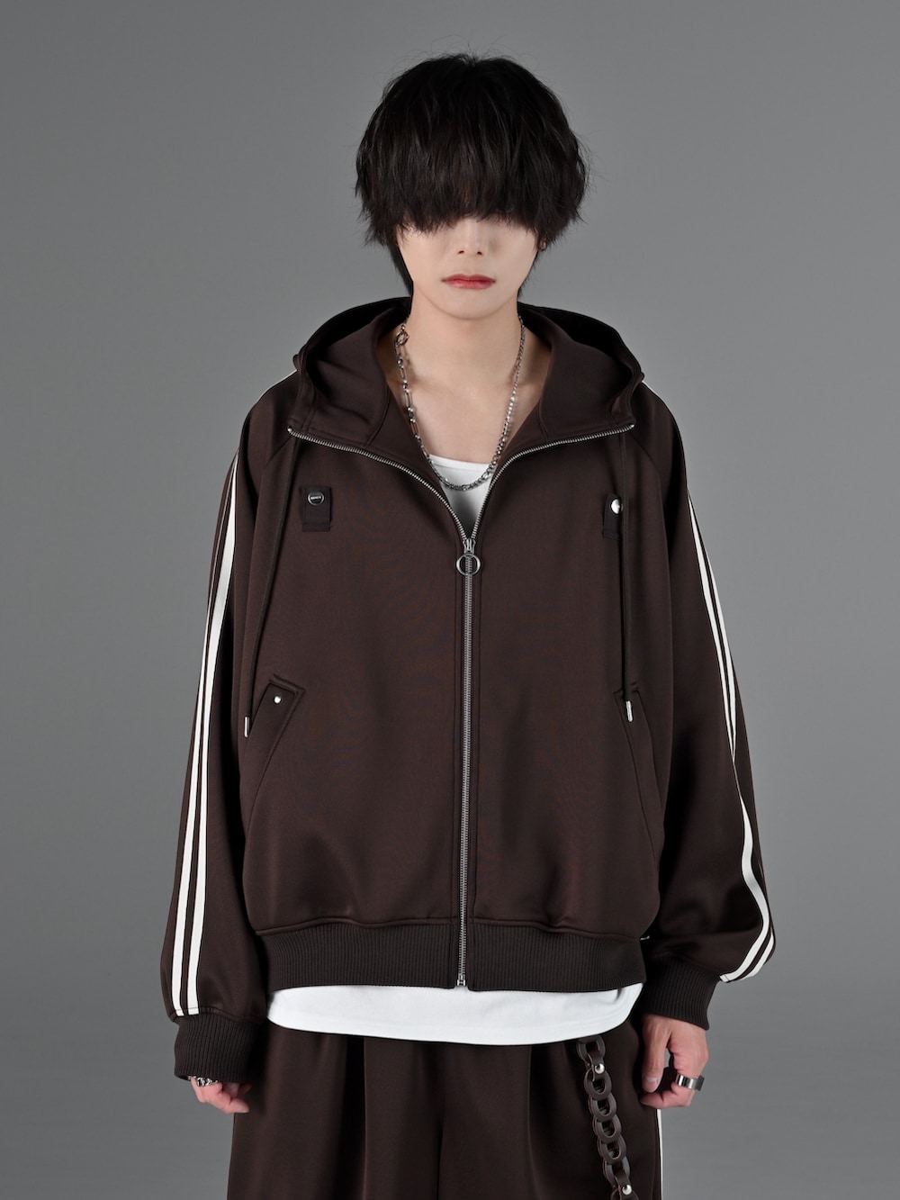 ブラック系のスニーカー、グレー系のタンクトップ、ブラウン系のブルゾンを着用したメンズの冬コーディネートの2枚目の写真