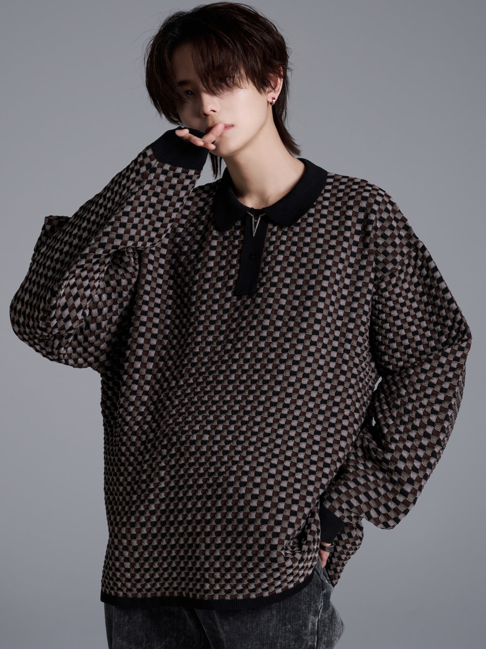 ブラック系のデニムパンツ、ブラウン系のポロシャツ、ブラック系のブーツを着用したメンズの冬コーディネートの3枚目の写真