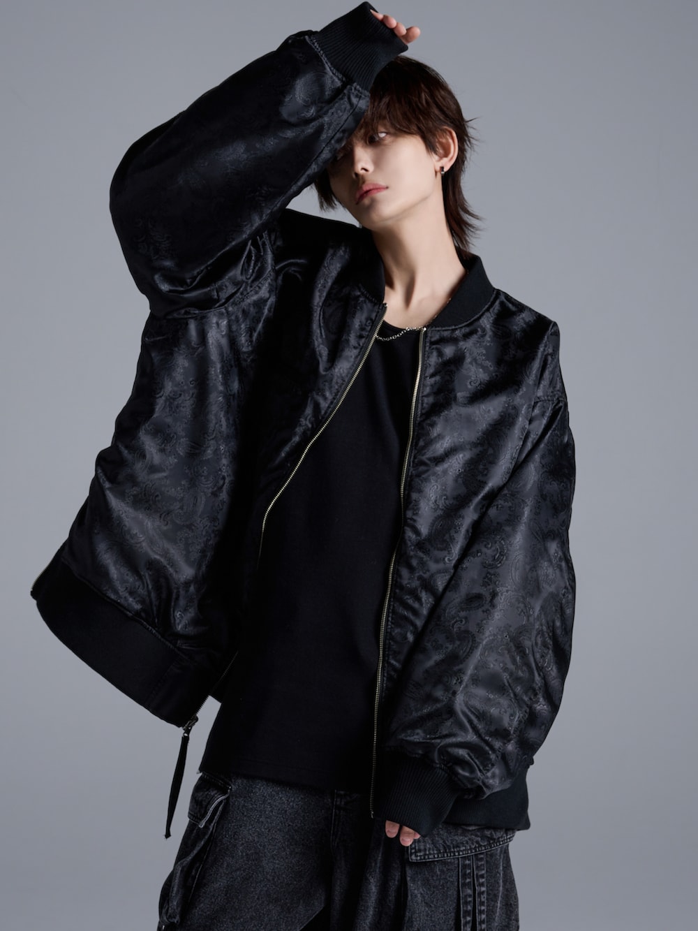 ブラック系のタンクトップ、ブラック系のMA-1、ブルー系のカーゴパンツを着用したメンズの冬コーディネートの3枚目の写真