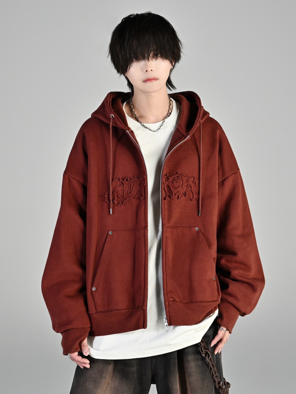 ブラウン系のパーカー、ブラック系のデニムパンツ、ブラック系のローファーを着用したメンズの冬コーディネートの3枚目の写真