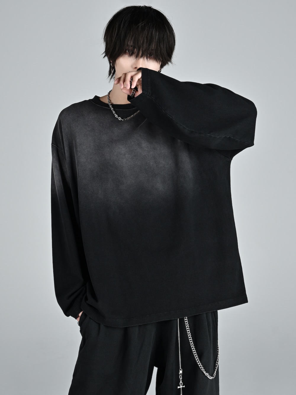 ブラック系のスウェットパンツ、ホワイト系のスニーカー、ブラック系のTシャツ/カットソーを着用したメンズの冬コーディネートの2枚目の写真