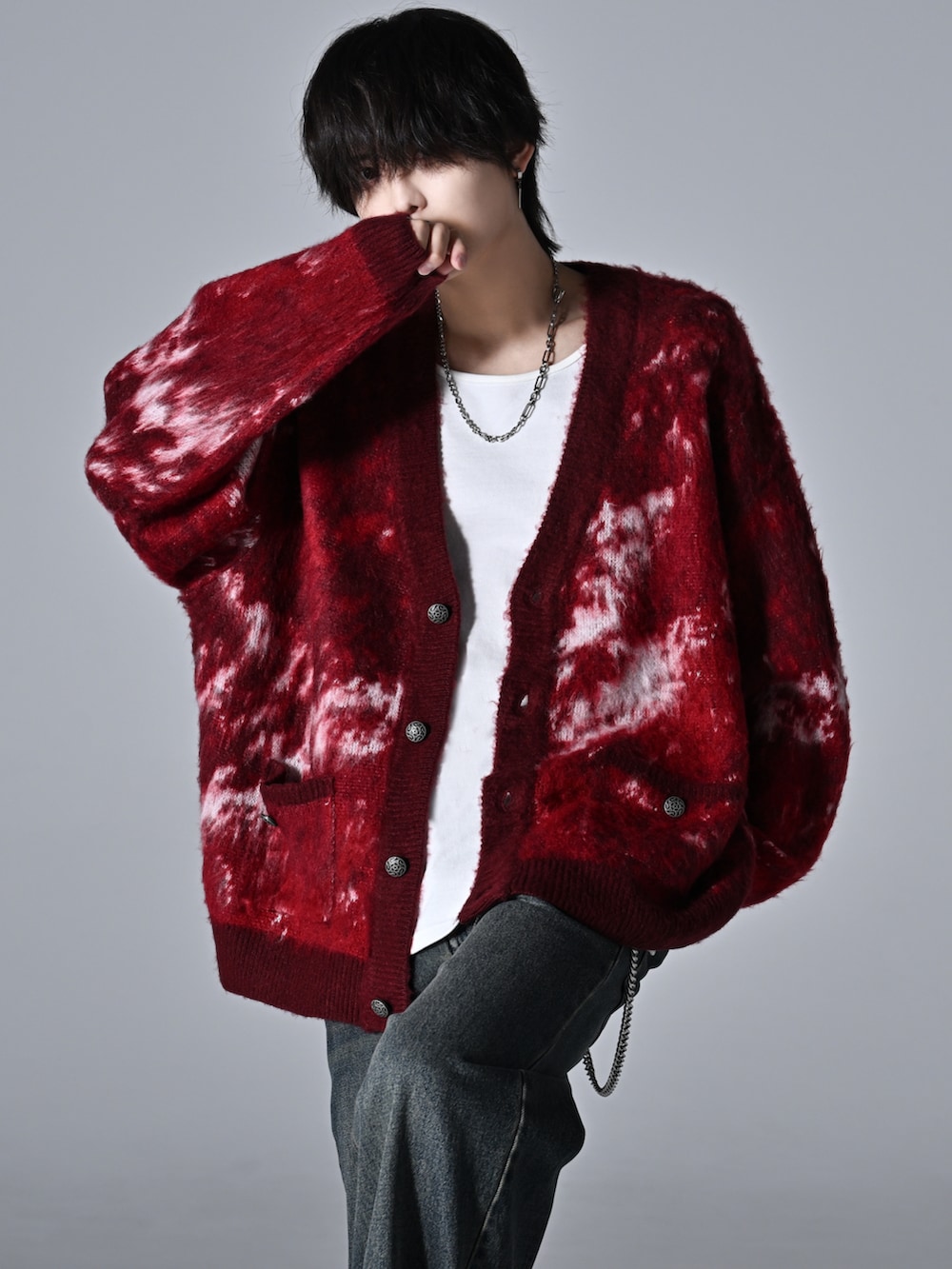 レッド系のカーディガン/ボレロ、グレー系のタンクトップ、ブルー系のデニムパンツを着用したメンズの秋コーディネートの2枚目の写真