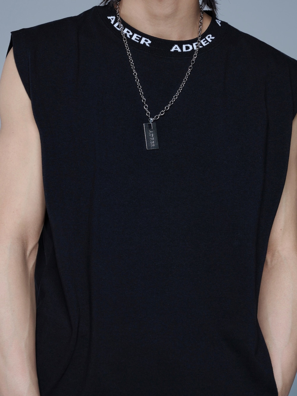 ブラック系のスニーカー、ブラック系のタンクトップ、ホワイト系のその他パンツを着用したメンズの春コーディネートの3枚目の写真