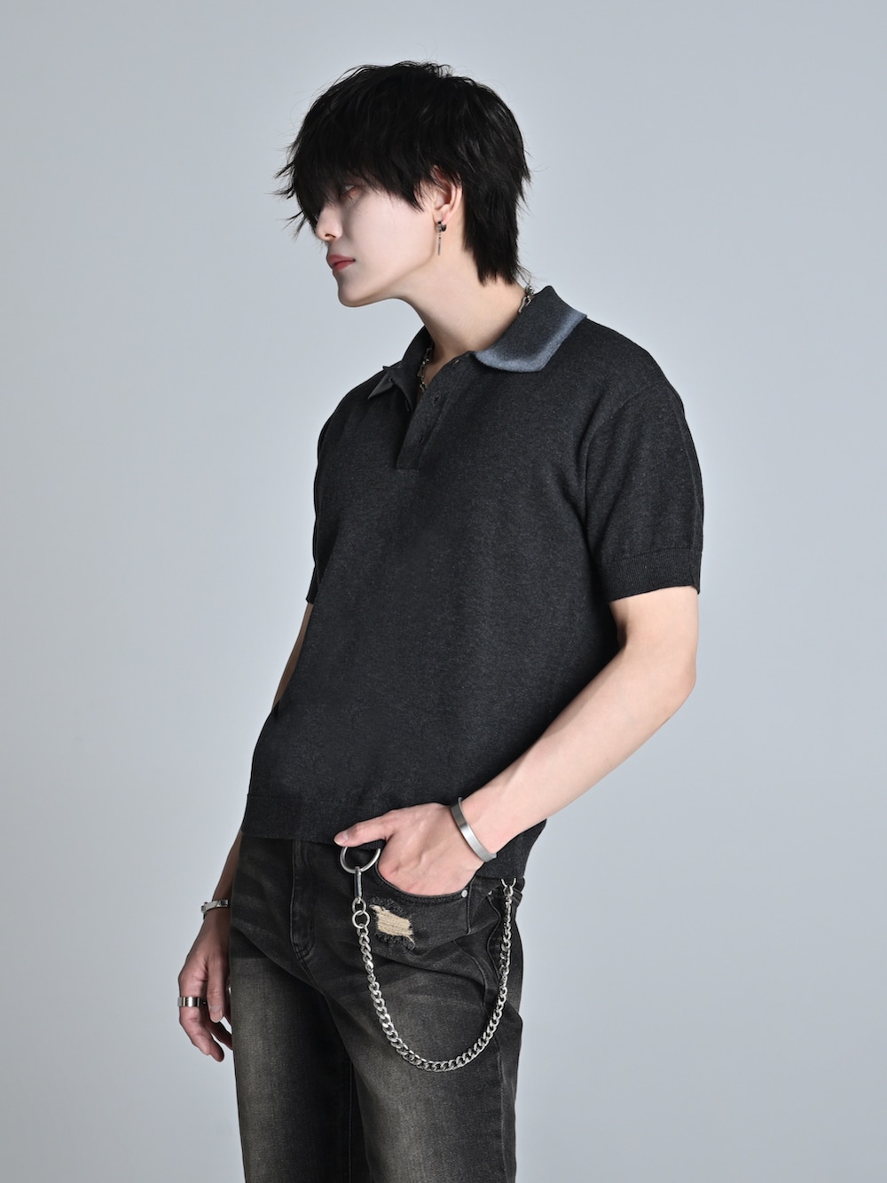 ブルー系のデニムパンツ、グレー系のポロシャツ、ブラック系のショルダーバッグを着用したメンズの春コーディネートの3枚目の写真