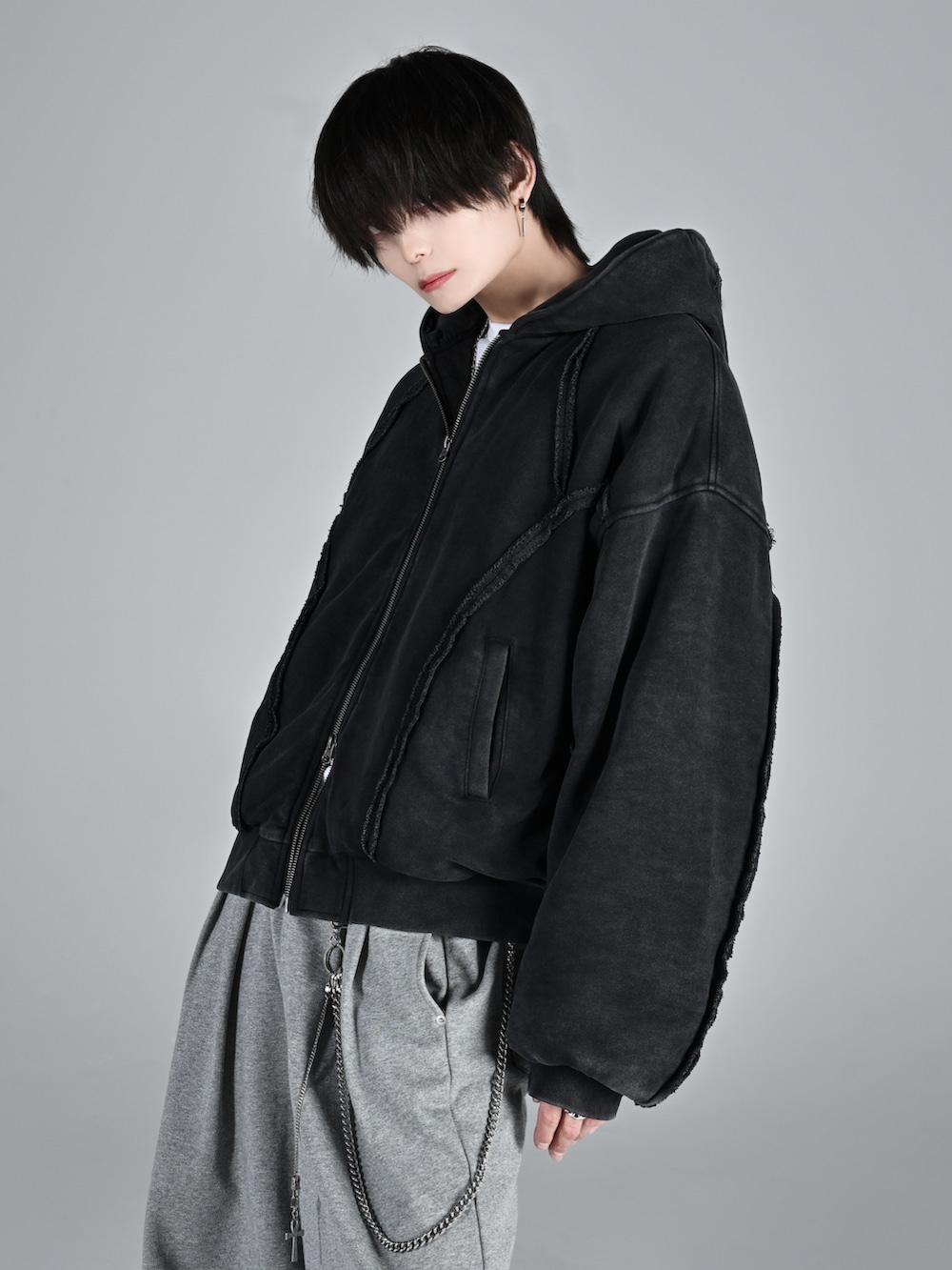 ベージュ系のブーツ、ブラック系のパーカー、グレー系のデニムパンツを着用したメンズの秋コーディネートの4枚目の写真