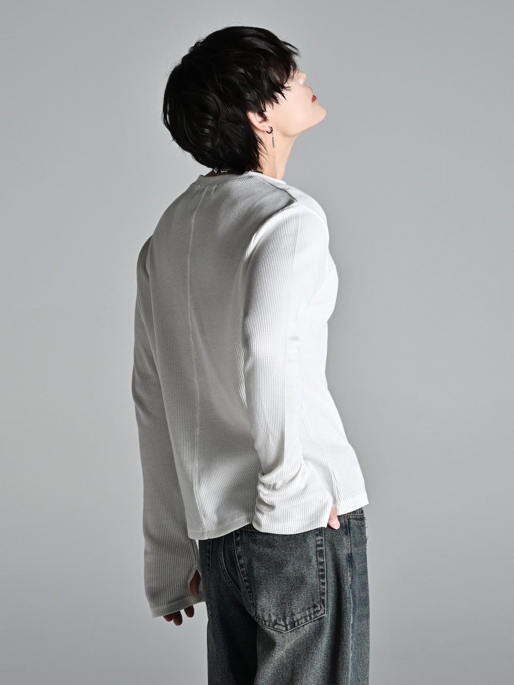 ブルー系のデニムパンツ、ブラック系のショルダーバッグ、ブラック系のブーツを着用したメンズの冬コーディネートの4枚目の写真