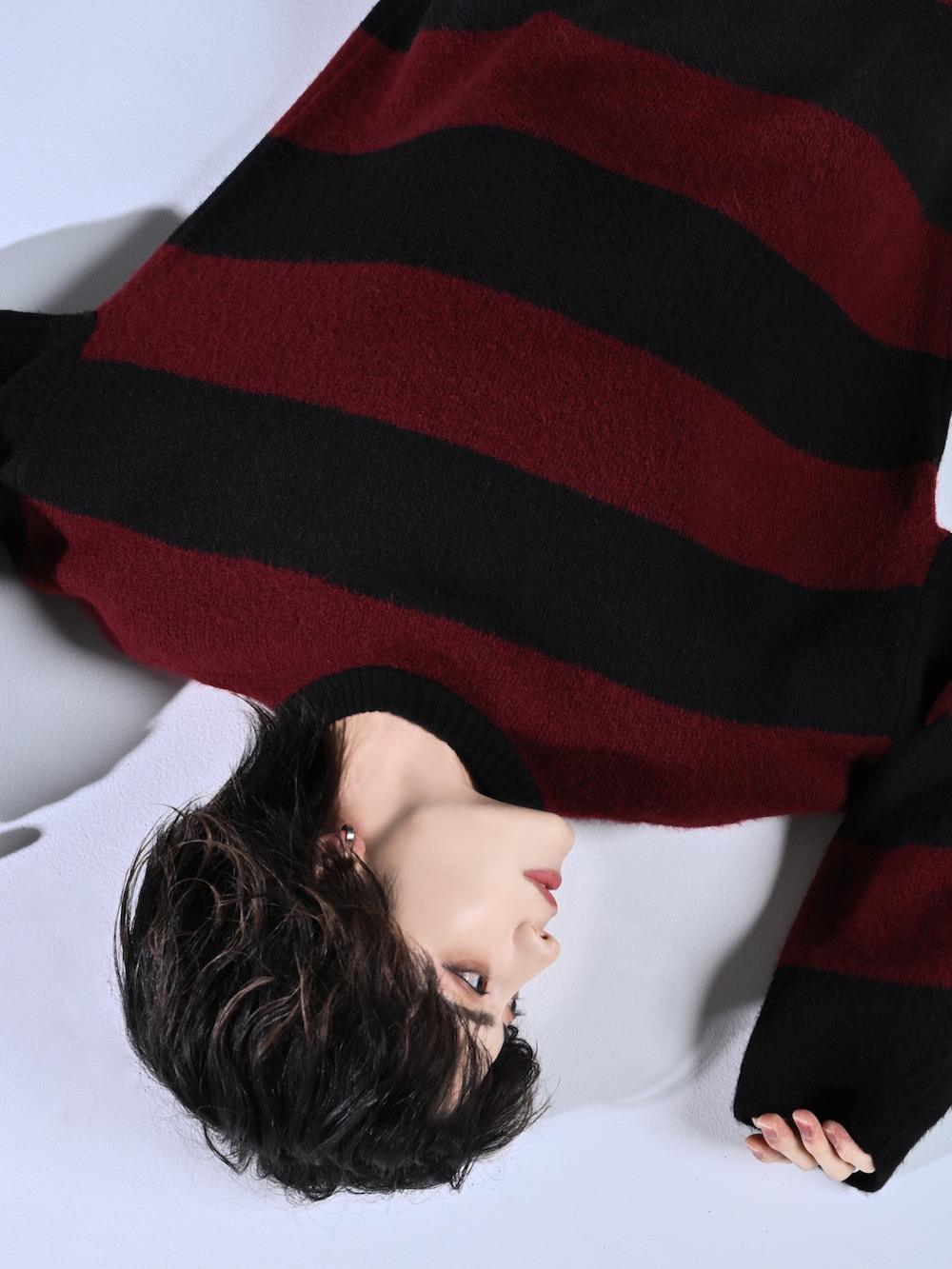 レッド系のニット/セーター、ブラック系のスラックス、ブラック系のスニーカーを着用したメンズの秋コーディネートの4枚目の写真