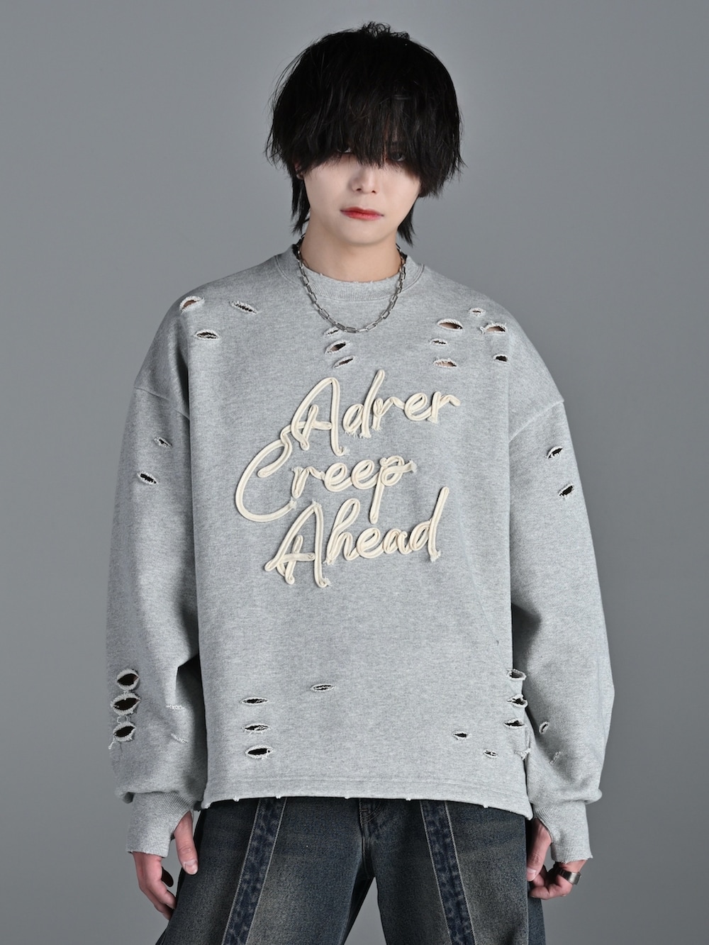 グレー系のスウェット、ブルー系のデニムパンツ、ホワイト系のスニーカーを着用したメンズの冬コーディネートの2枚目の写真