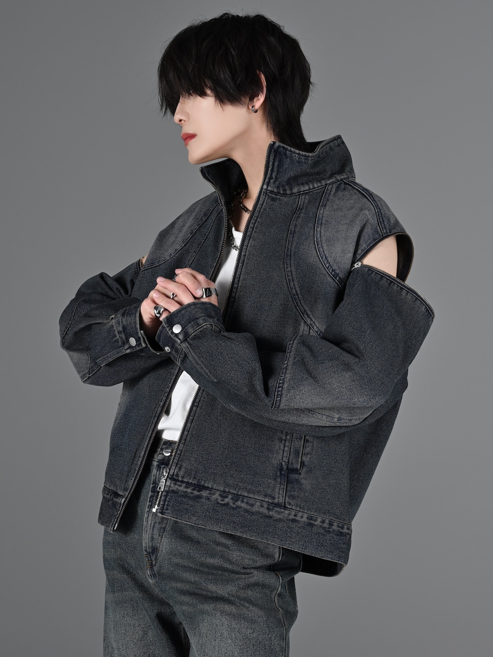 ブルー系のデニムパンツ、ホワイト系のスニーカー、グレー系のタンクトップを着用したメンズの冬コーディネートの4枚目の写真