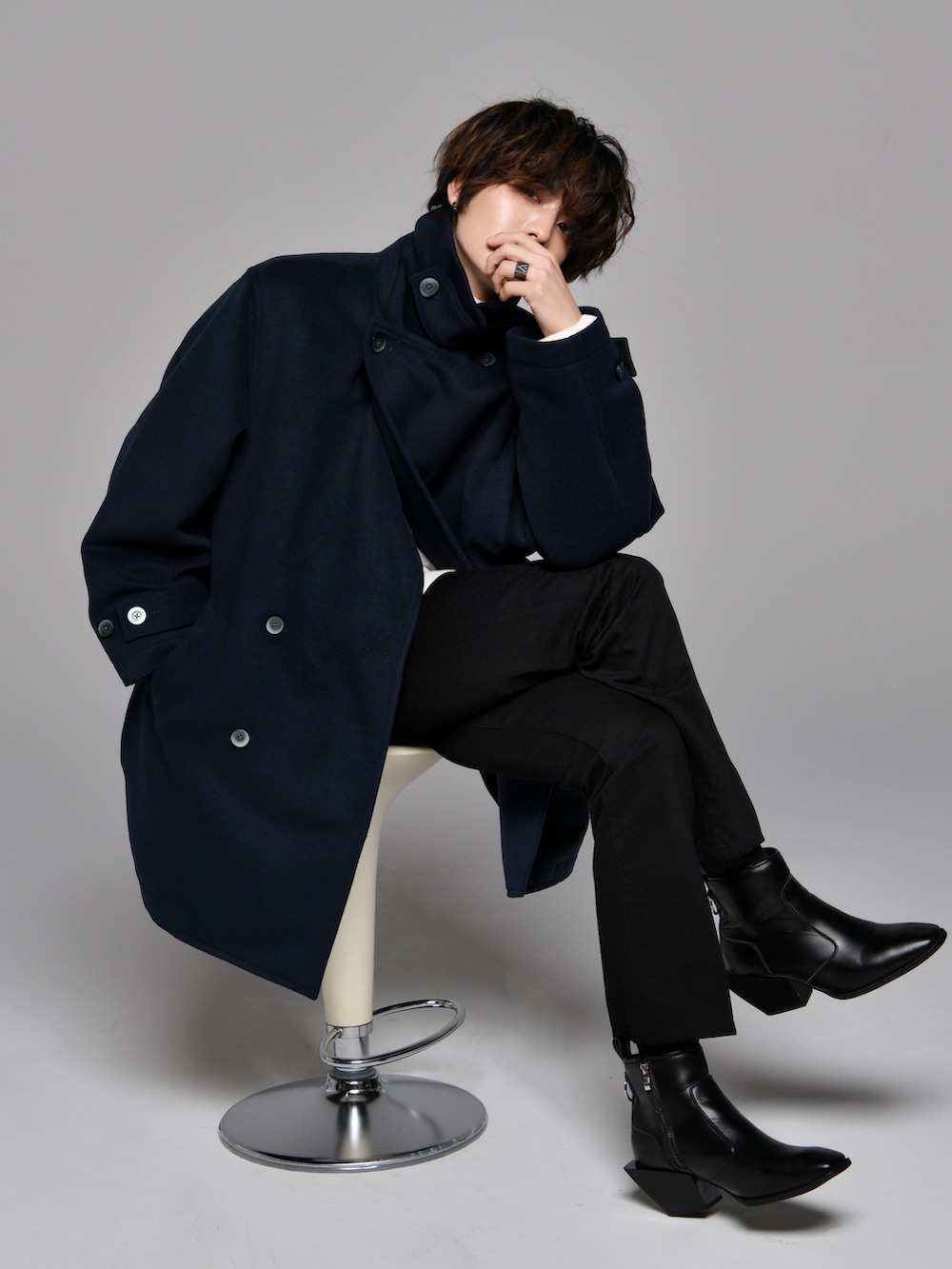 ブラック系のスラックス、ブラック系のブーツ、ホワイト系のニット/セーターを着用したメンズの秋コーディネートの2枚目の写真