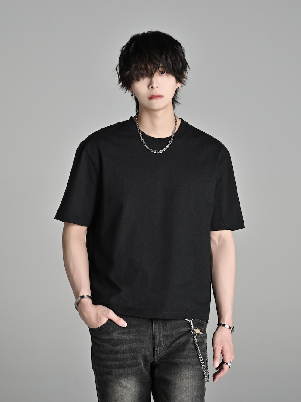 ブラック系のデニムパンツ、ブラック系のブーツ、ブラック系のTシャツ/カットソーを着用したメンズの春コーディネートの2枚目の写真