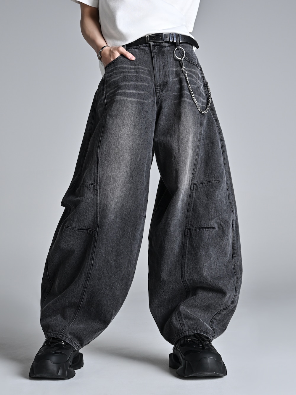 ブラック系のショルダーバッグ、ホワイト系のスニーカー、グレー系のニット/セーターを着用したメンズの冬コーディネートの3枚目の写真