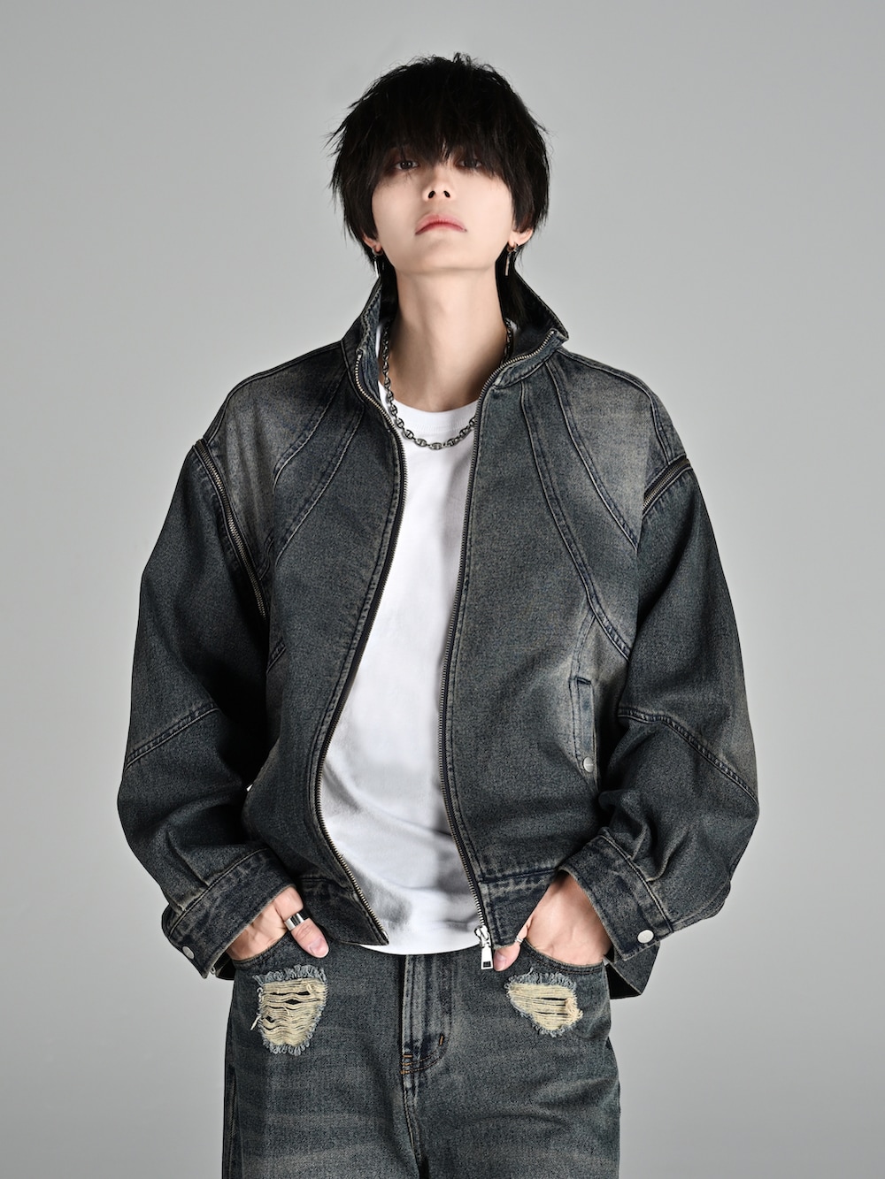 ブラック系のパーカー、ブルー系のデニムジャケット、ブラック系のカーゴパンツを着用したメンズの冬コーディネートの2枚目の写真