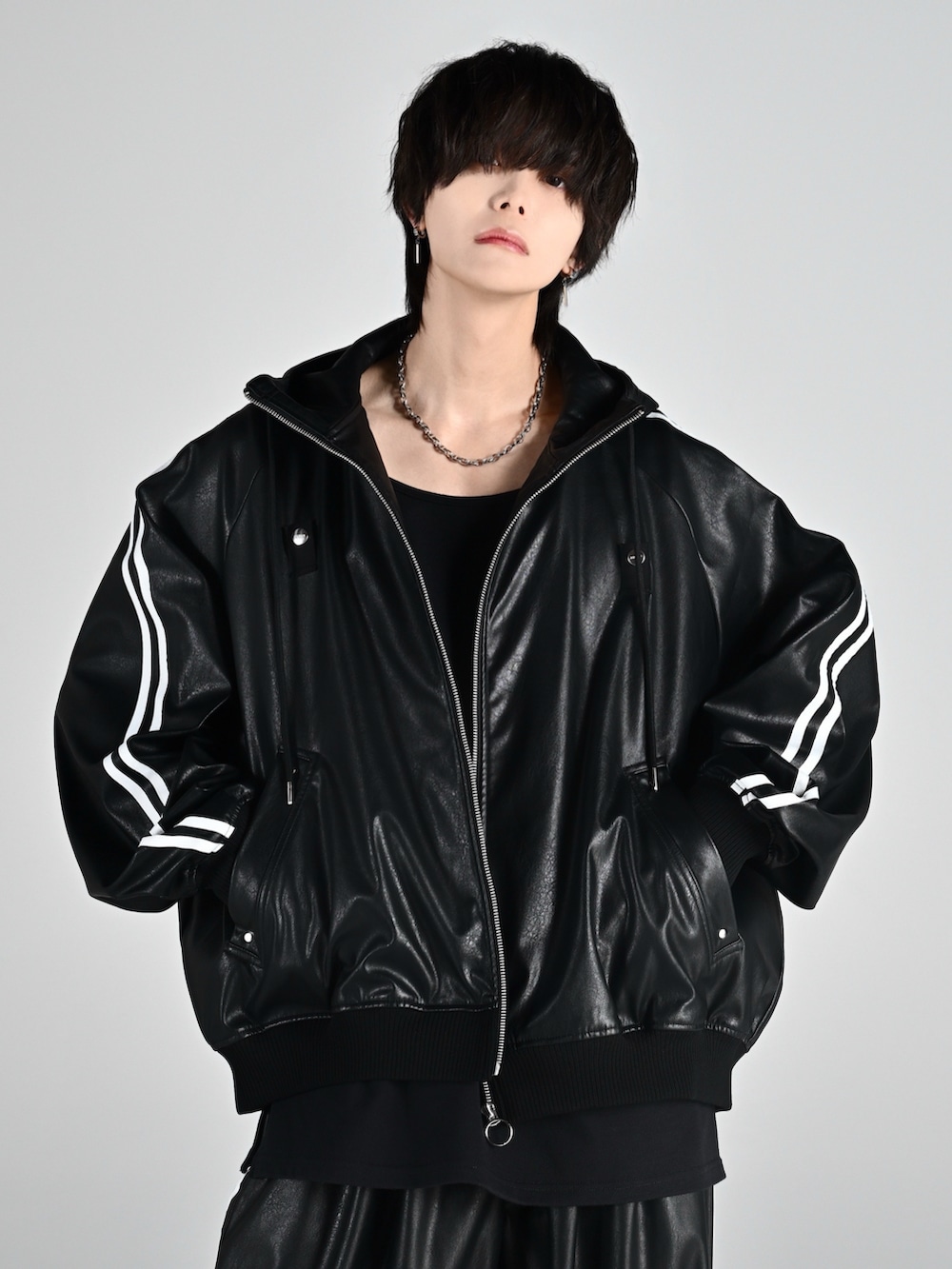 レッド系のタンクトップ、ブラック系のブーツ、ブラック系のブルゾンを着用したメンズの夏コーディネートの2枚目の写真